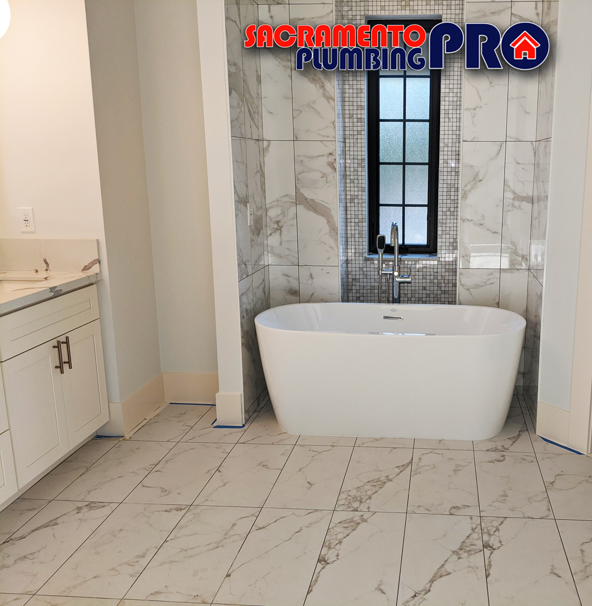 Elegant bathroom remodeled by Sacramento Plumbing Pro featuring a modern freestanding tub and marble tiles.
