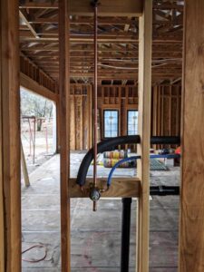 New residential pipe installation within the framing of a Clarksville home, exemplifying precision plumbing.