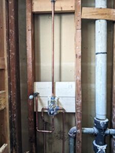 In-wall plumbing setup in Sacramento, with pipes and fixtures expertly mounted between studs.